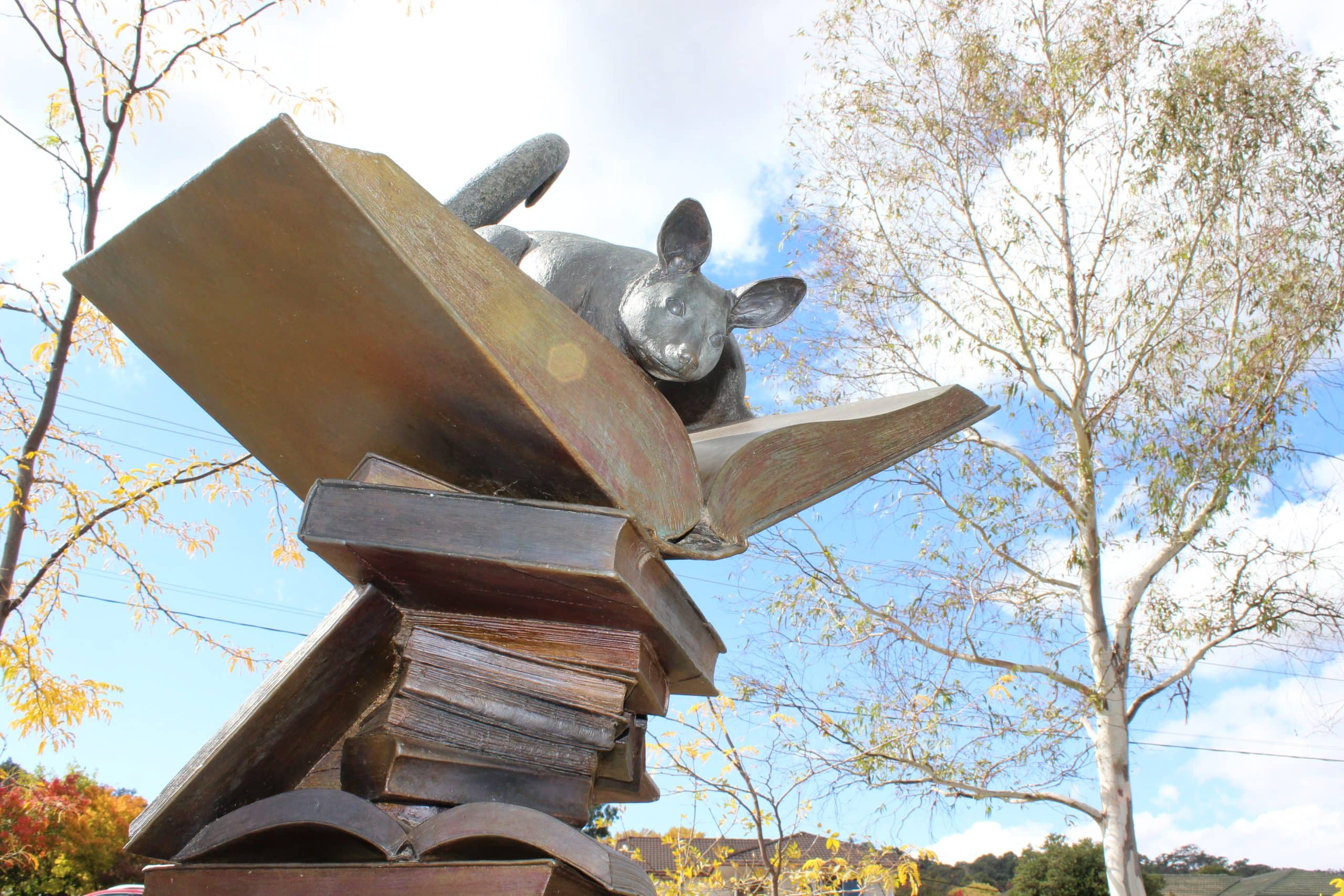 Sculpture of a possum on top of a stack of books